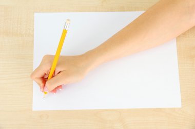 ahşap zemin üzerinde beyaz kağıt kalem ile el
