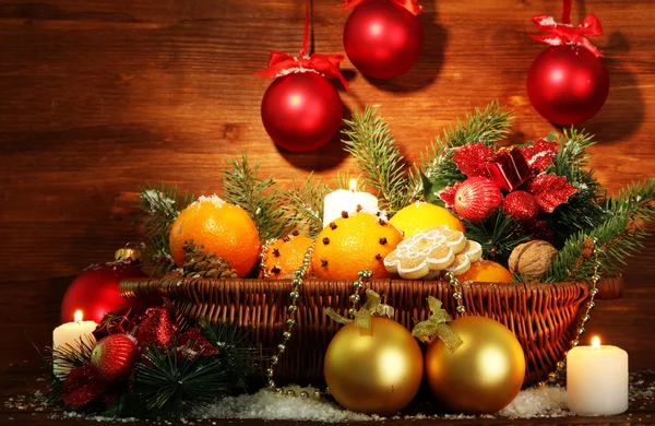 Christmas composition in basket with oranges and fir tree, on wooden background — Stock Photo, Image