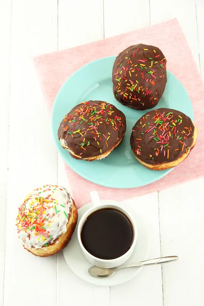 Donuts saborosos na placa de cor no fundo de madeira leve — Fotografia de Stock