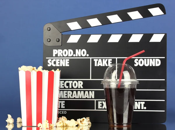 Película clapperboard, cola y palomitas de maíz sobre fondo azul — Foto de Stock