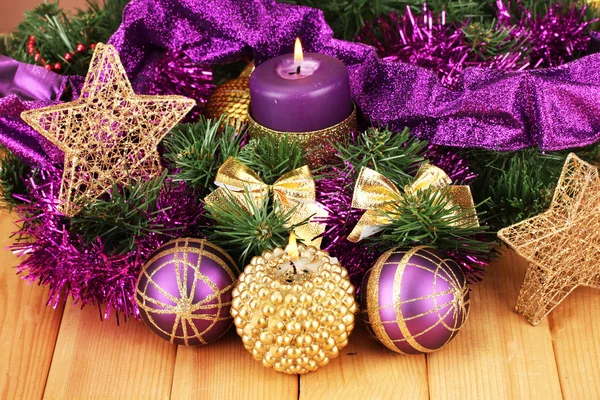 Composição de Natal com velas e decorações em roxo e ouro cores sobre fundo de madeira — Fotografia de Stock