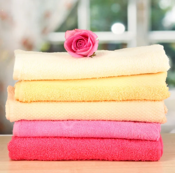 Montón de toallas con flor fragante en el fondo de la ventana — Foto de Stock