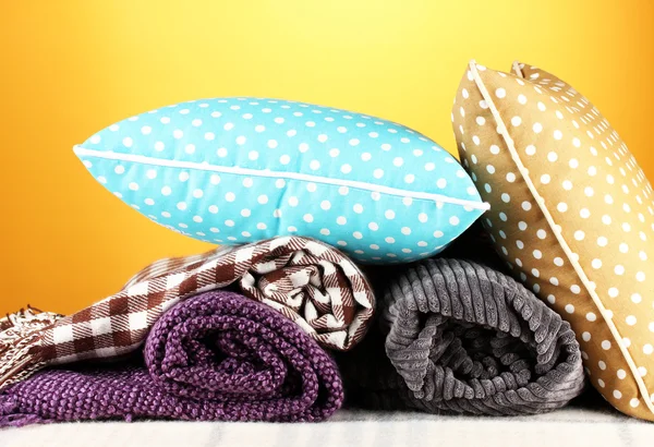 Plaids and color pillows on yellow background — Stock Photo, Image