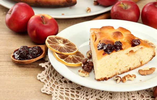 Ломтик вкусного домашнего пирога с джемом и яблоками, на деревянном столе — стоковое фото