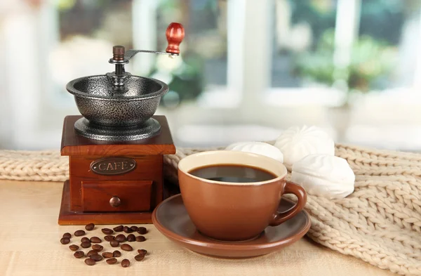 Filiżanka kawy z szalikiem i kawa młyn na stole w pokoju — Zdjęcie stockowe
