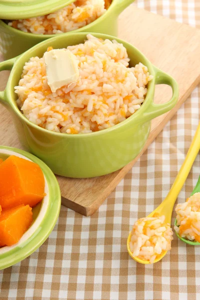 Taste rice porridge with pumpkin in saucepans on tablecloth background — Stock Photo, Image