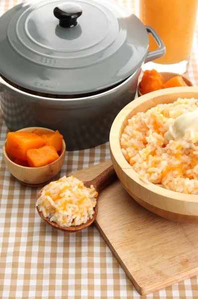 Prove mingau de arroz com abóbora e copo de suco no fundo de toalha de mesa — Fotografia de Stock