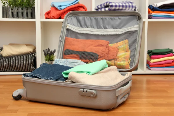 Valise ouverte grise avec vêtements dans la chambre — Photo