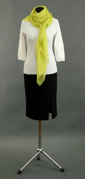 Witte blouse, zwarte rok en groene sjaal op etalagepop op grijze achtergrond — Stockfoto
