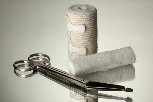 First aid kit for bandaging on grey background