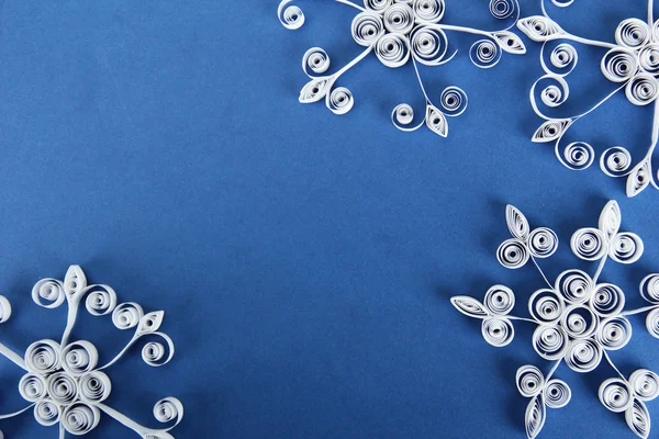 Bellissimi fiocchi di neve di carta, su sfondo blu — Foto Stock