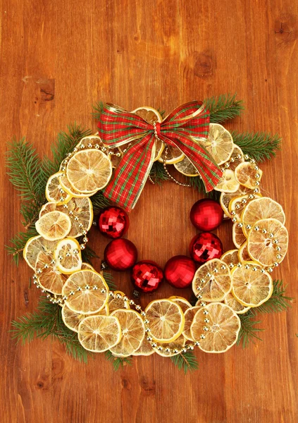 Corona de Navidad de limones secos con abeto y bolas, sobre fondo de madera —  Fotos de Stock