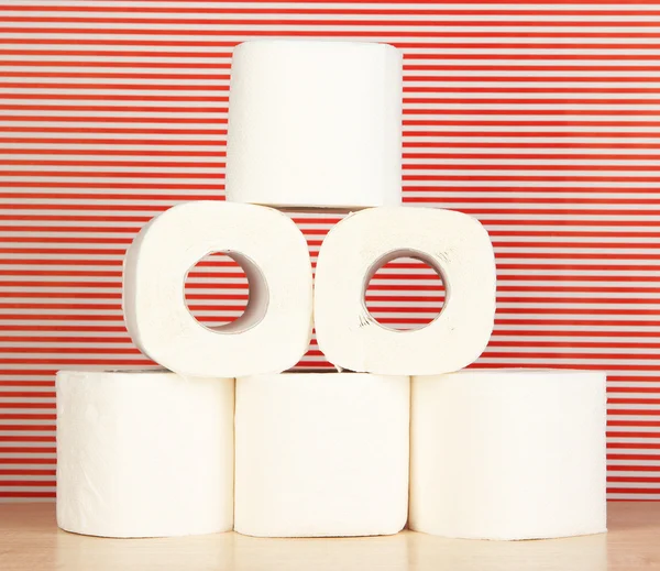 Rollos de papel higiénico sobre fondo rojo rayado — Foto de Stock