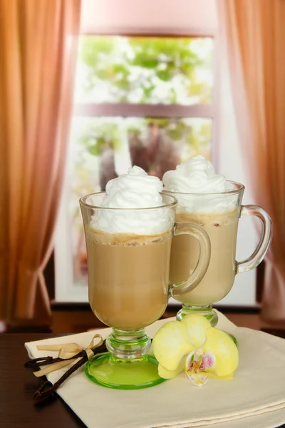 Caffè caffelatte profumato in tazze di occhiali con baccelli di vaniglia, su tavolo in caffè — Foto Stock