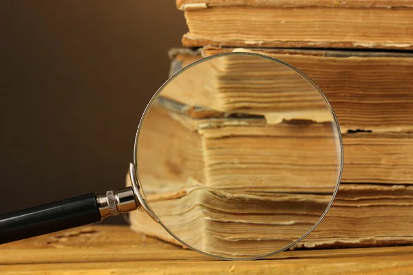 Vergrootglas en boeken op tafel — Stockfoto