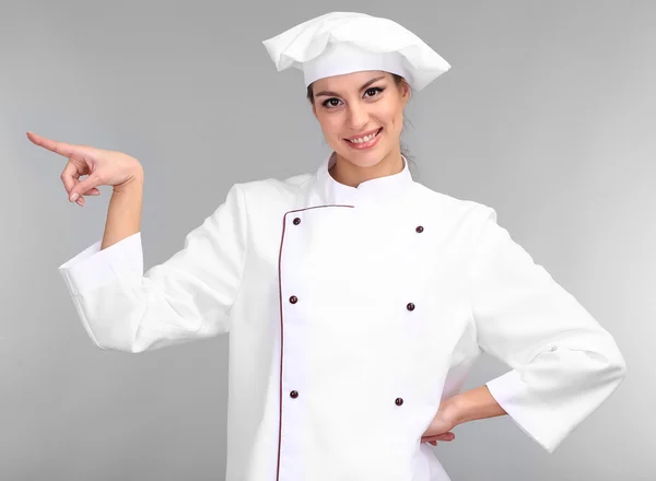 Retrato de una joven chef sobre fondo gris — Foto de Stock