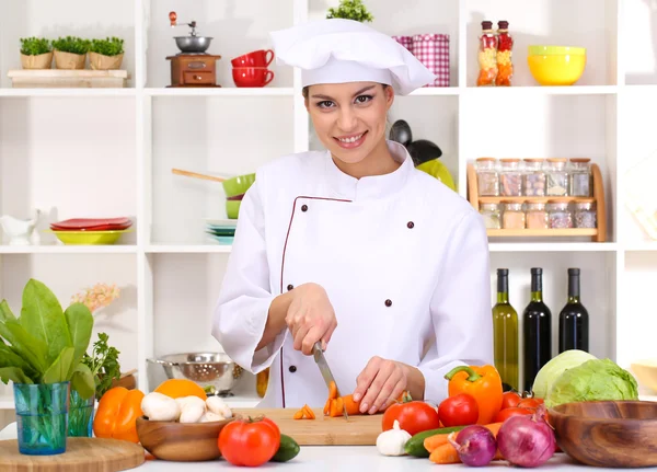 Young woman chef cooking in kitchen — Stock Photo, Image