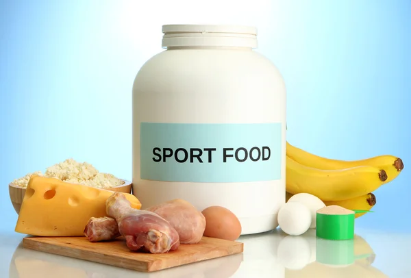 Jar of protein powder and food with protein, on blue background — Stock Photo, Image