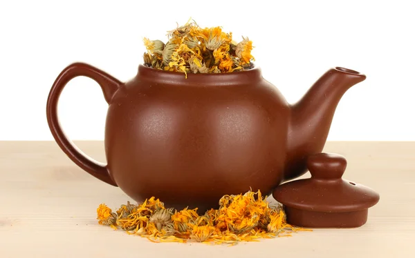 Ervas secas em bule de chá sobre mesa de madeira, isoladas em branco. Foto conceitual de chá de ervas . — Fotografia de Stock