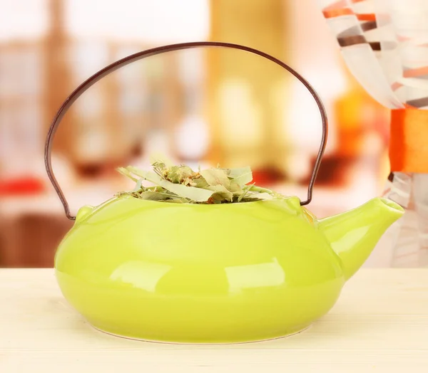 Ervas secas no bule de chá na mesa de madeira, no fundo brilhante. Foto conceitual de chá de ervas . — Fotografia de Stock