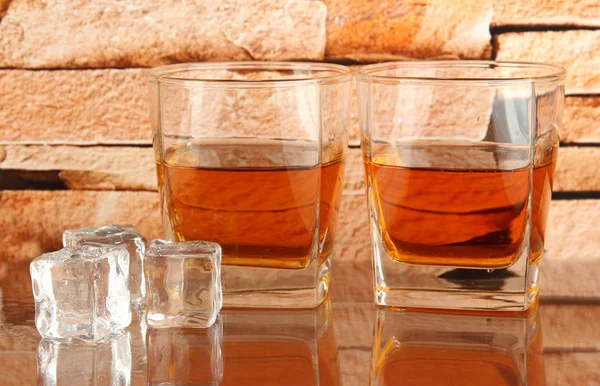 Vasos de whisky y hielo sobre fondo de pared de ladrillo —  Fotos de Stock