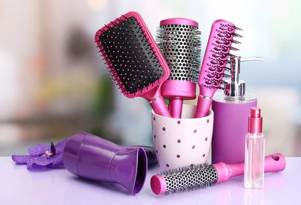 Hair brushes, hairdryer and cosmetic bottles in beauty salon — Stock Photo, Image