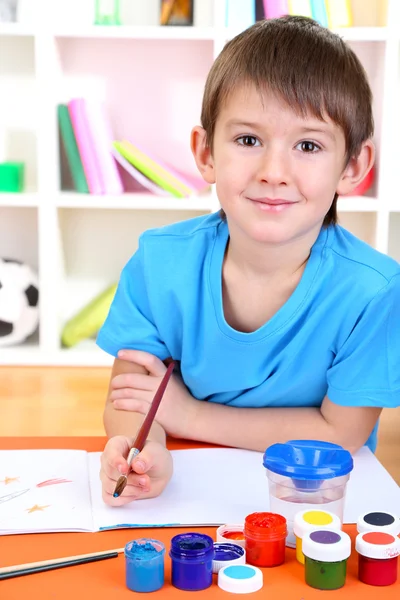 Симпатичный маленький мальчик рисует в своем альбоме — стоковое фото