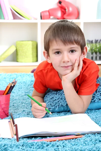 Симпатичный маленький мальчик рисует в альбоме — стоковое фото