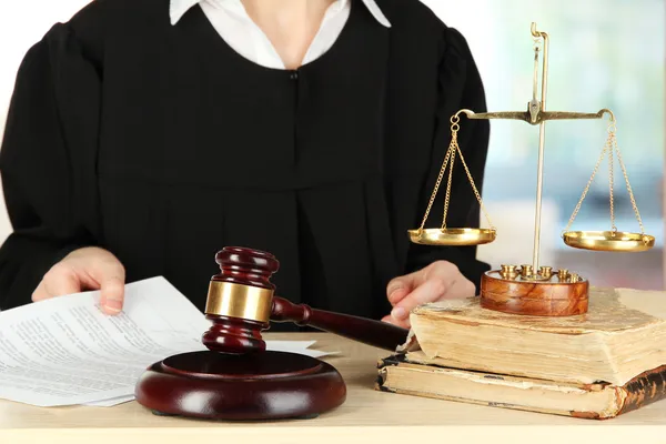 Juiz sentado à mesa durante as audiências judiciais sobre o fundo da sala — Fotografia de Stock