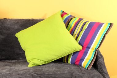 kanepede sarı arka plan üzerinde renkli yastıklar