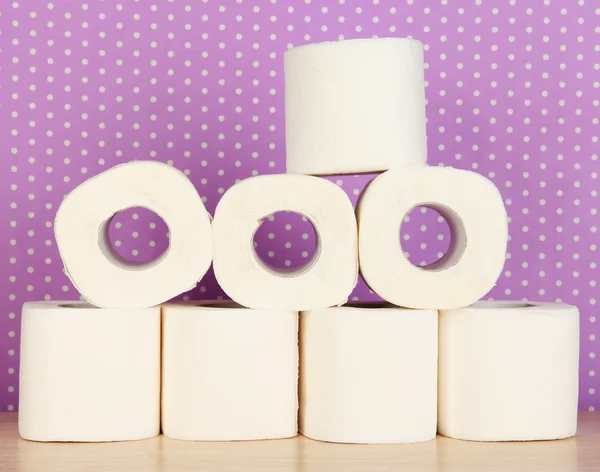 Rolls of toilet paper on purple with dots background — Stockfoto