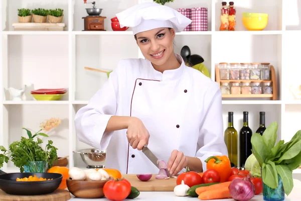 Young woman chef cooking in kitchen — Stock Photo, Image