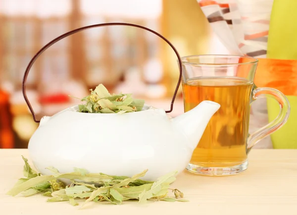 Dried herbs in teapot on wooden table, on bright background. Conceptual photo of herbal tea. — Stock Photo, Image