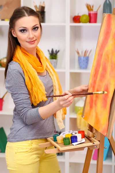 Schöne junge Malerin bei der Arbeit, auf Rauminterieur Hintergrund — Stockfoto