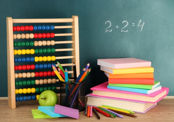 Abaco giocattolo, libri e matite sul tavolo, sullo sfondo della scrivania della scuola — Foto Stock