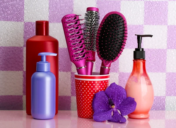 Hair brushes and cosmetic bottles in bathroom — Stock Photo, Image