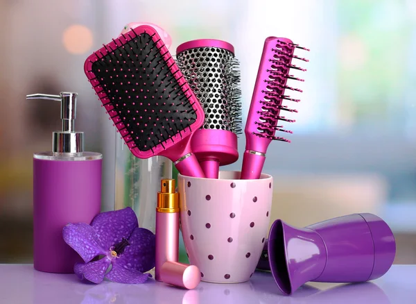 Hair brushes, hairdryer and cosmetic bottles in beauty salon — Stock Photo, Image