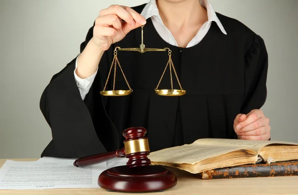 Judge sitting at table during court hearings on grey background — Stock Photo, Image