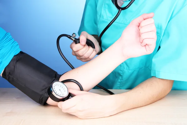 Blood pressure measuring on blue background Stock Image