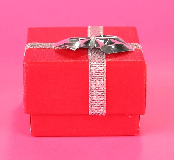 Boîte cadeau couleur avec ruban argenté, sur fond de couleur — Photo