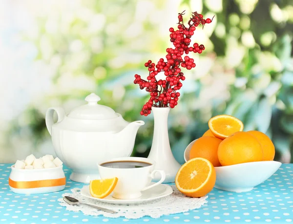 Hermoso servicio de cena blanca con naranjas en mantel azul sobre fondo natural — Foto de Stock