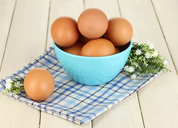 Eggs in blue bowl on wooden table close-up — Stock Photo, Image