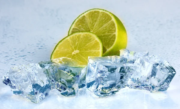 Ice cubes with lime on light yellow background — Stock Photo, Image