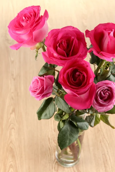 Красивые розовые розы в вазе на деревянном столе крупным планом — стоковое фото