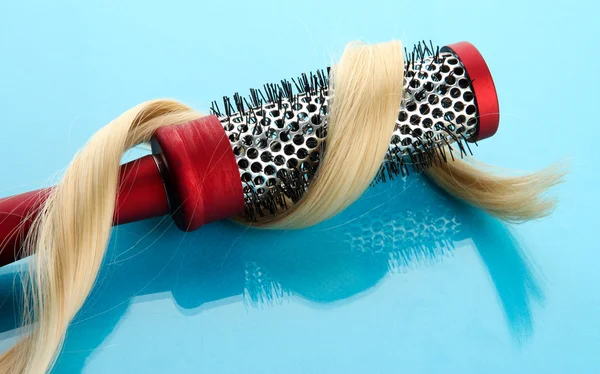 Cepillo de peine con pelo, sobre fondo azul — Foto de Stock