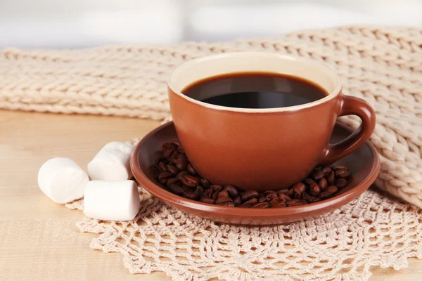 Tasse de café avec écharpe sur la table dans la chambre — Photo