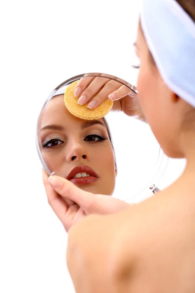 Giovane donna che pulisce il viso, isolata su bianco — Foto Stock
