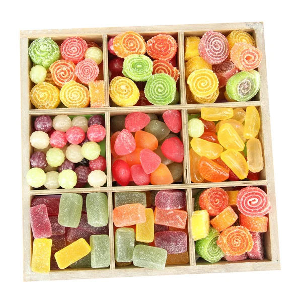 Ahşap kutusunda, çok renkli şekerleri üzerine beyaz izole — Stok fotoğraf