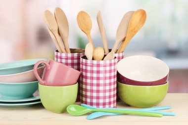 Cups, bowls nd other utensils in metal containers isolated on light background