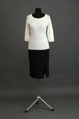 Beyaz bluz ve manken üzerinde gri arka plan üzerinde siyah etek